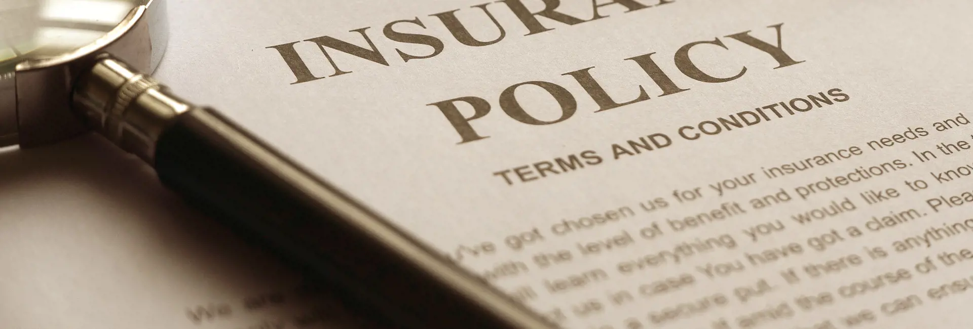 Close-up of an insurance policy document with a magnifying glass placed on top