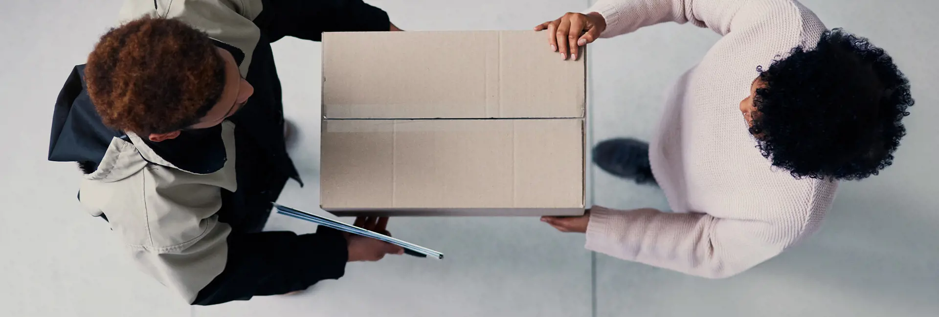 Top-down view of an onboard courier handing a cardboard box to a recipient, symbolizing fast and secure delivery