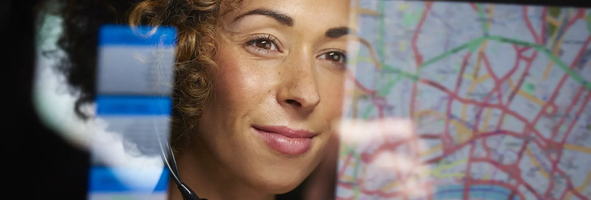 Logistics specialist with a headset analyzing a digital map, representing Scan Global Logistics' technology-driven solutions