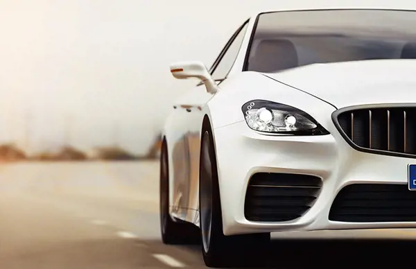 White luxury car driving on a sunny road, showcasing its sleek design and performance