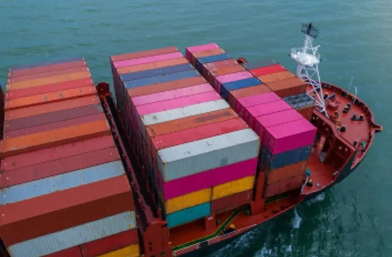 Scan Global Logistics container ship sailing with stacked cargo containers across calm waters