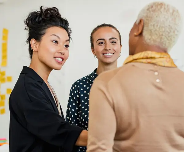 Three diverse Scan Global Logistics team members engaging in a collaborative conversation in an office setting