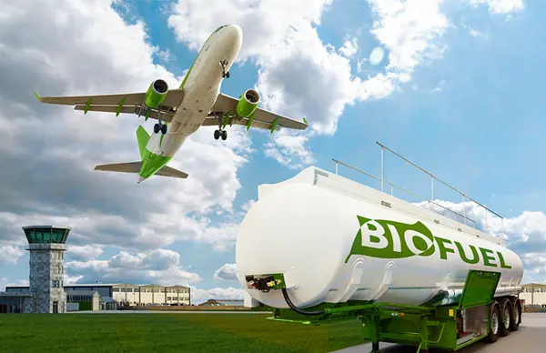 Airplane taking off near a biofuel tanker marked 'BIOFUEL' at an airport